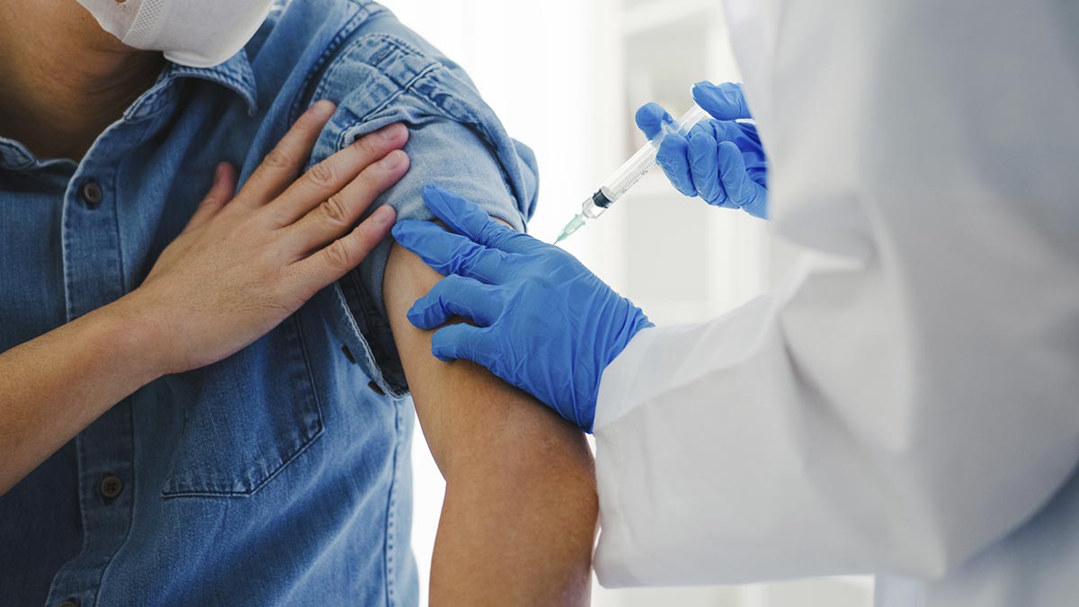 Médico aplicando vacina em braço de paciente
